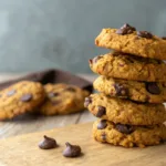 stack of healthy pumpkin oat cookies with chocolate chips on wood table