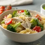 Rotini pasta with rotisserie chicken, broccoli, cherry tomatoes, and Parmesan cheese