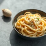 creamy garlic fettuccine pasta with Parmesan on gray background