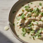 Bowl of creamy white chicken chili with herbs